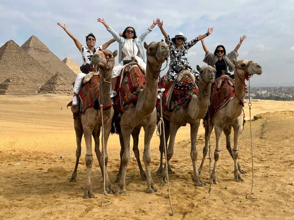 Tourists on camels taking a tour of the Giza pyramids