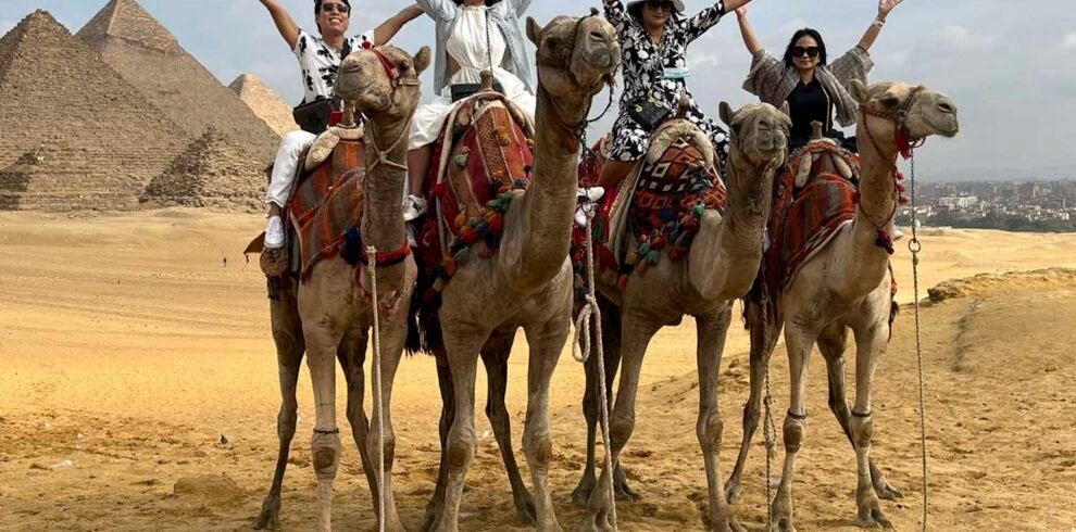 Tourists on camels taking a tour of the Giza pyramids