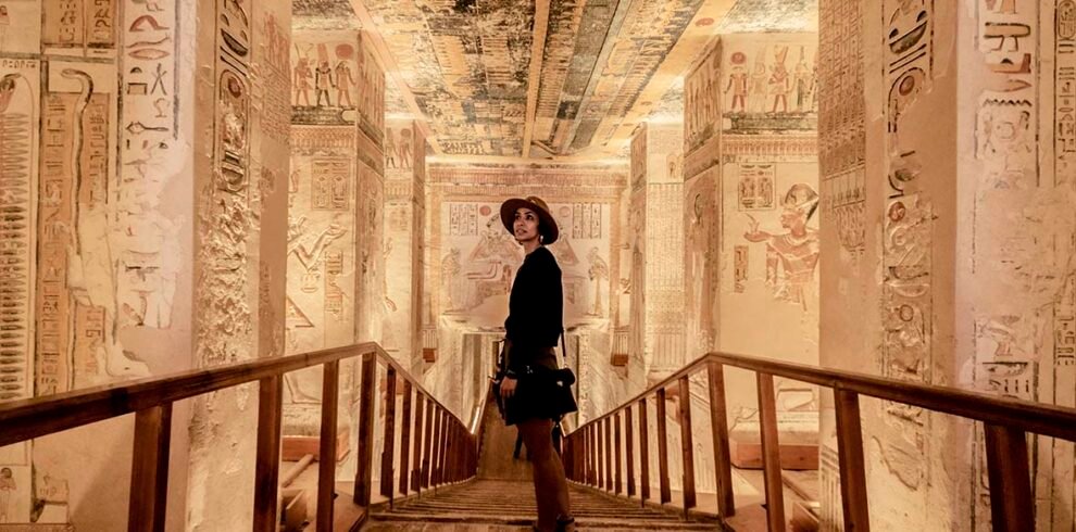 wide view photo of a tourist standing inside a tomb in the Valley of the kings in luxor